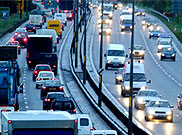 image of six lane highway with median showing bumper to bumper cars and trucks traveling both directions on this busy road