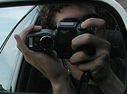 image of person taking photos from car