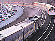 image of railway train next to busy highway